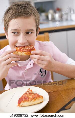 Stock Image - Boy eating a piece of pizza. Fotosearch