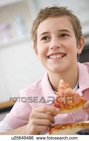 Boy eating a piece of pizza View Large Photo Image Stock Photograph - Boy eating a piece of pizza. Fotosearch