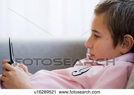 Boy playing with mobile phone View Large Photo Image Stock Image - Boy playing with mobile phone. Fotosearch