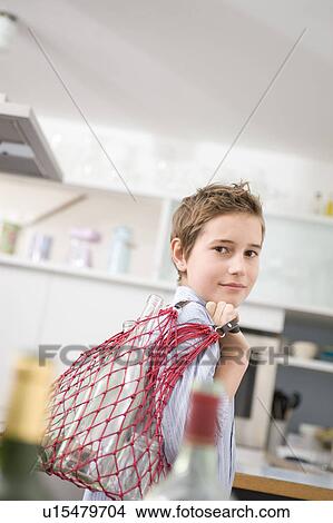 Picture - Boy recycling empty bottles. Fotosearch