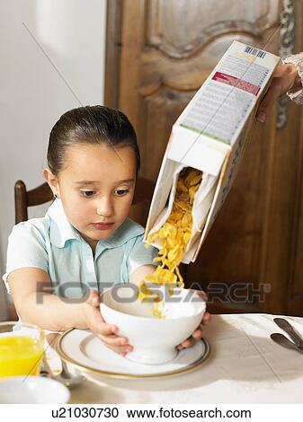 Girl (4-6) holding out bowl cereal View Large Photo Image Stock Image - Girl (4-6) holding out bowl cereal. Fotosearch