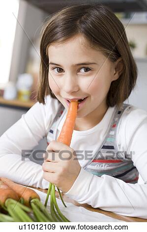 Stock Photo - Girl eating a carrot. Fotosearch