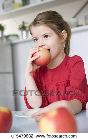 Stock Image - Girl eating an apple. Fotosearch