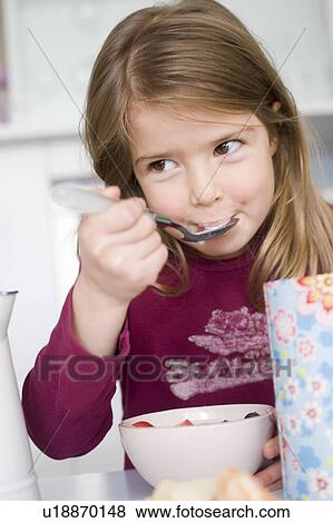 Stock Photo - Girl eating cereals and fruit. Fotosearch