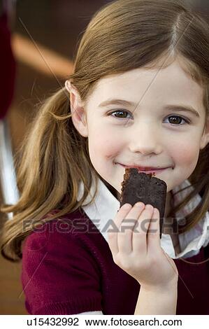 Stock Image - Girl eating chocolate cake. Fotosearch