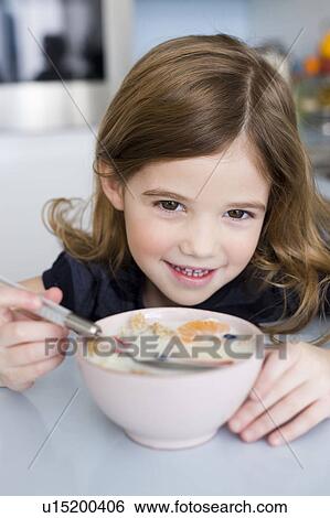 Stock Photograph - Girl eating fruit and yogurt. Fotosearch