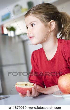 Girl having half an apple in her hand View Large Photo Image Stock Photo - Girl having half an apple in her hand. Fotosearch