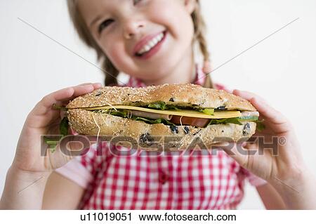 Stock Image - Girl holding sandwich. Fotosearch