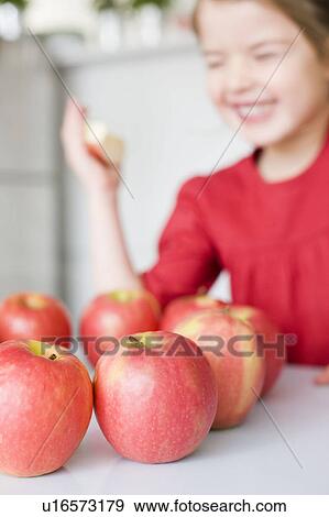 Girl laughing behind some apples View Large Photo Image Stock Photo - Girl laughing behind some apples. Fotosearch