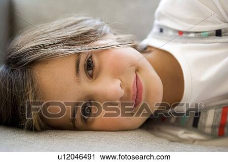Girl lying and looking into the camera View Large Photo Image Stock Image - Girl lying and looking into the camera. Fotosearch