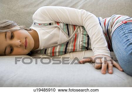Stock Image - Girl lying on sofa. Fotosearch