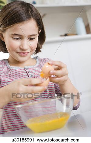 Girl separating egg yolk and egg white View Large Photo Image Stock Image - Girl separating egg yolk and egg white. Fotosearch