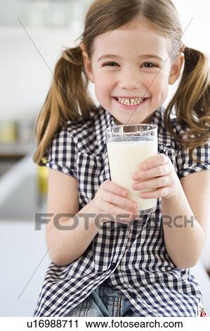 Stock Image - Girl smiling at camera holding glass. Fotosearch
