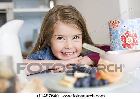 Stock Image - Girl smiling behind some health food. Fotosearch