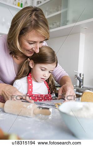 Picture - Mother and daughter preparing dough. Fotosearch