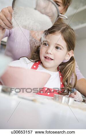 Mother and daughter sifting flour View Large Photo Image Stock Photo - Mother and daughter sifting flour. Fotosearch