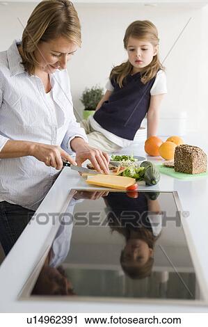 Mother preparing sandwich for daughter View Large Photo Image Stock Image - Mother preparing sandwich for daughter. Fotosearch