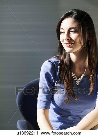 Businesswoman sitting in office, smiling View Large Photo Image Stock Image - Businesswoman sitting in office, smiling. Fotosearch