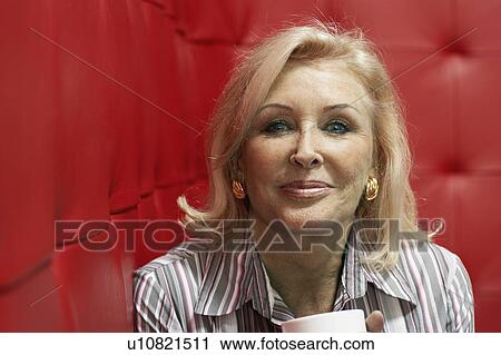 Businesswoman working at a table with red seating View Large Photo Image Stock Image - Businesswoman working at a table with red seating. Fotosearch