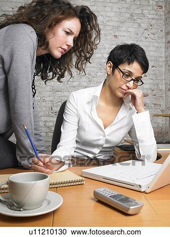 Two businesswomen working on a laptop., Brussels, Belgium. View Large Photo Image Stock Image - Two businesswomen working on a laptop., Brussels, Belgium.. Fotosearch