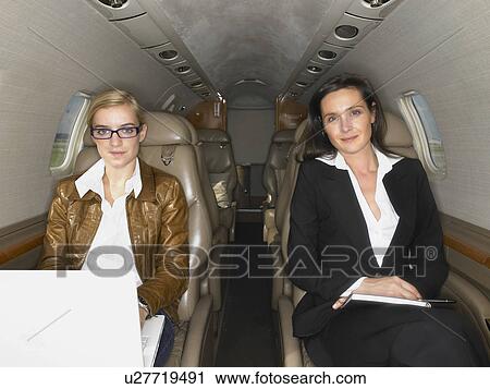Two women sitting in a private jet. View Large Photo Image Stock Image - Two women sitting in a private jet.. Fotosearch