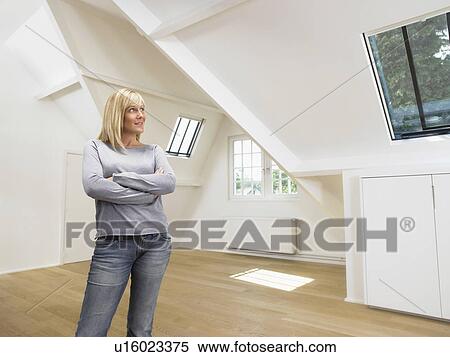 Stock Photography - Woman arms crossed into empty white loft.. Fotosearch