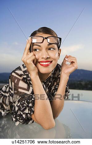 Woman pushing eyeglasses up onto head smiling outdoors. View Large Photo Image Stock Photograph - Woman pushing eyeglasses up onto head smiling outdoors.. Fotosearch