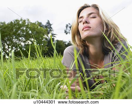 Woman relaxing in a green field. View Large Photo Image Stock Image - Woman relaxing in a green field.. Fotosearch