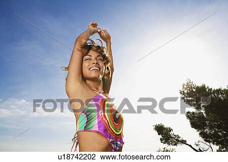 Woman standing outdoors with arms raised smiling. View Large Photo Image Stock Image - Woman standing outdoors with arms raised smiling.. Fotosearch