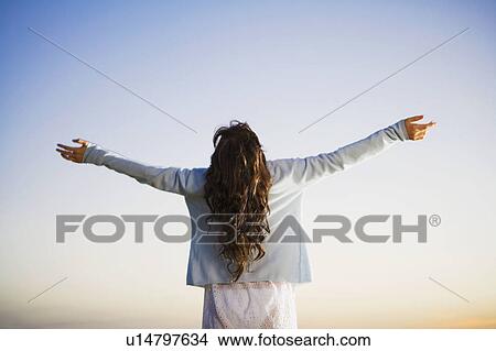 Woman standing with arms outstretched. View Large Photo Image Picture - Woman standing with arms outstretched.. Fotosearch