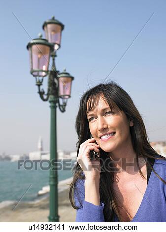 Woman talking on mobile phone. Venice, Italy. View Large Photo Image Stock Image - Woman talking on mobile phone. Venice, Italy.. Fotosearch