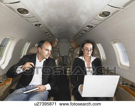 Businesswoman and businessman in private jet having a discussion. View Large Photo Image Stock Image - Businesswoman and businessman in private jet having a discussion.. Fotosearch