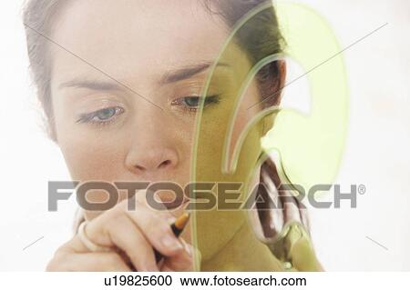 Stock Image - Close-Up portrait of woman through window using graphic drawing equipment.. Fotosearch