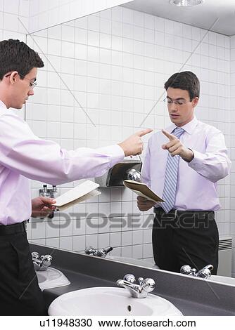 Man practicing speech in office washroom mirror View Large Photo Image Stock Image - Man practicing speech in office washroom mirror. Fotosearch
