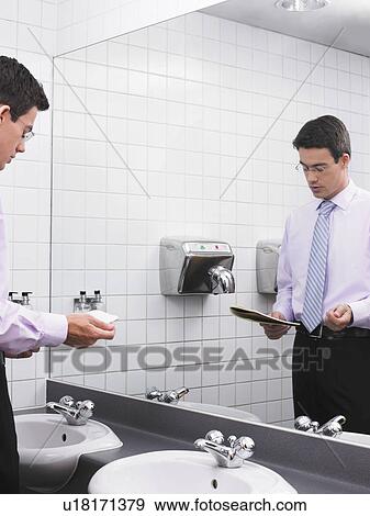 Man practicing speech in office washroom mirror View Large Photo Image Stock Photo - Man practicing speech in office washroom mirror. Fotosearch