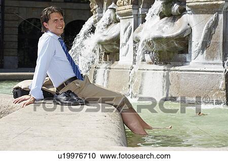 Stock Image - Smiling businessman in fountain.. Fotosearch