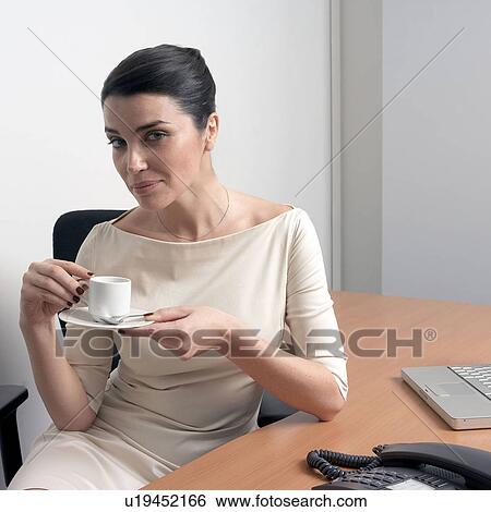 Woman in office holding cup View Large Photo Image Stock Photograph - Woman in office holding cup. Fotosearch