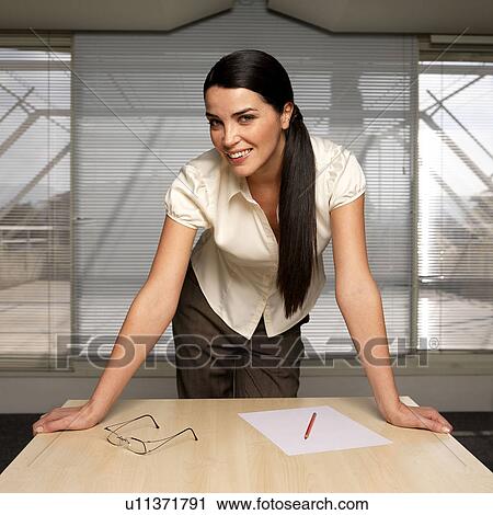 Woman leaning on desk, portrait View Large Photo Image Stock Image - Woman leaning on desk, portrait. Fotosearch