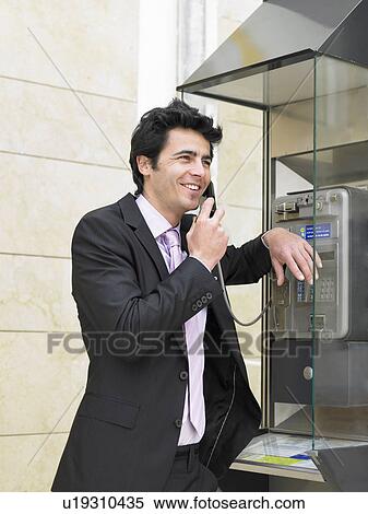 Young man in suit talking on public phone, Alicante, Spain, View Large Photo Image Stock Photography - Young man in suit talking on public phone, Alicante, Spain,. Fotosearch