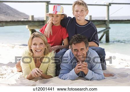 Stock Image - A family laying on a beach. Fotosearch