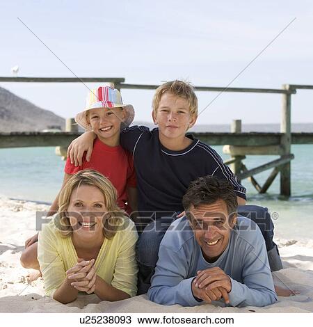 A family laying on a beach View Large Photo Image Stock Image - A family laying on a beach. Fotosearch