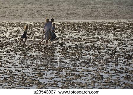 Stock Photo - A family on a beach. Fotosearch