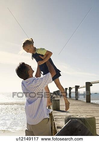 Stock Photo - A father and daughter on a beach. Fotosearch