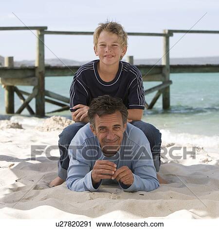 Stock Image - A father and son on a beach. Fotosearch