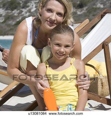 A mother applying sunscreen on her daughter View Large Photo Image Picture - A mother applying sunscreen on her daughter. Fotosearch