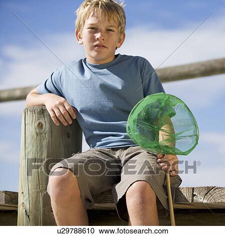 Stock Image - A young boy with a fishing net. Fotosearch