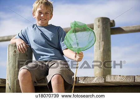 Stock Photo - A young boy with a fishing net. Fotosearch