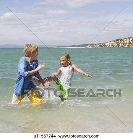 Two children playing in the sea View Large Photo Image Picture - Two children playing in the sea. Fotosearch