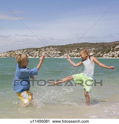 Stock Image - Two children playing in the sea. Fotosearch