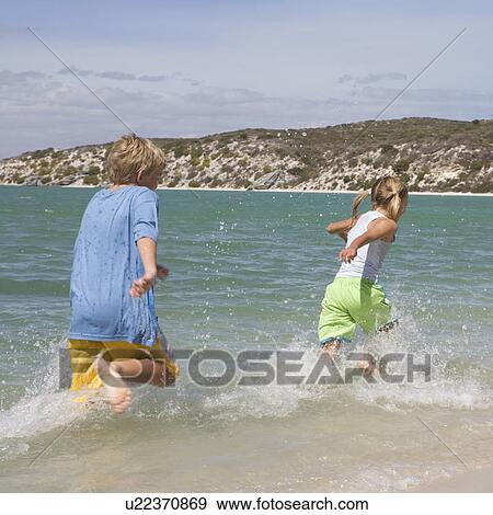 Stock Photo - Two children playing in the sea. Fotosearch